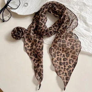 Detail shot of chic leopard print long silk scarf featuring elegant rose flower accessory design.