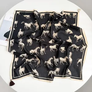 Detailed close-up of luxury black horse pattern silk square scarf featuring elegant tassel hem.