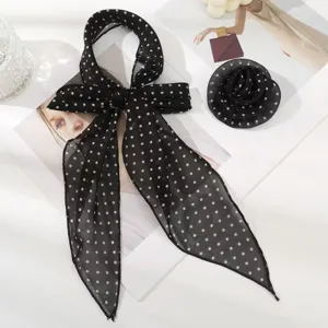 Close-up details of black polka dot ribbon silk scarf and elegant rose flower accessory.
