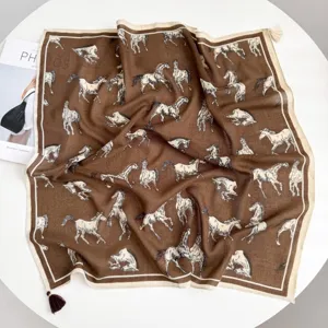 Detailed view of the luxury equestrian horse print square scarf with delicate tassel trim.