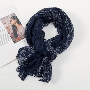 Detailed view of women's dark blue floral crinkle voile scarf, soft fabric texture close-up.