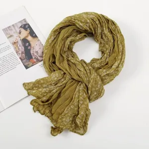 Close-up detail of olive green crinkled floral scarf with twisted texture, spring voile shawl.