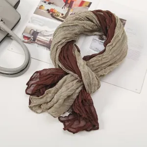 Close-up detail of soft pleated two-tone scarf in khaki and brown, showing voile texture.