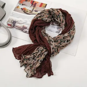 Detailed shot of women's floral pleated scarf, showcasing lightweight fabric and chic texture.