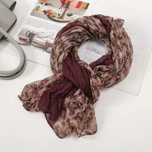 Detail view of lightweight floral patchwork scarf, showing soft texture and rich maroon color.