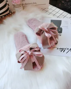 Detailed shot of women's cozy plush open-toe slippers featuring a handmade bow design.