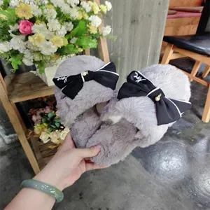 Detail view of cute faux wool women slippers featuring a chic black bow, cozy home indoor wear.