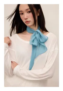 Light blue pleated ribbon scarf detail shot, elegant neck wear for spring and summer fashion.