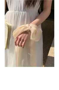 Details of the solid pleated chiffon ribbon scarf tied on wrist, soft elegant aesthetic style.