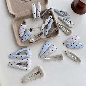 Detail view of Korean style polka dot hair clips, featuring cute fabric and metal snap designs.