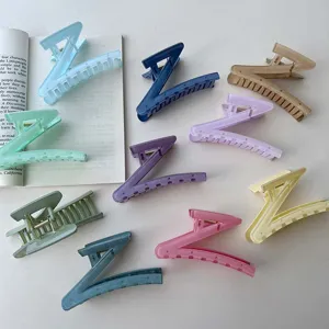 Detailed close-up shot of colorful Z-shaped glitter hair claw clips in assorted candy tones.