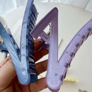 Close-up detail of large Z-shaped glitter hair claw clip, stylish candy color hair accessory.