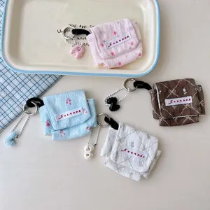 Gedetailleerd overzicht van stoffen oortelefoon opbergzakjes met leuke print en handige sleutelhanger.