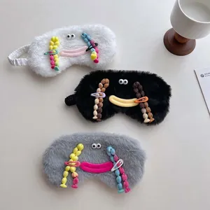 Plush funny sleepy eye mask detail showing soft furry texture, cute quirky face and colorful beads.