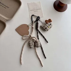 Gedetailleerde close-up van schattige pluche kat ruit sleutelhanger en hartvormige hanger.