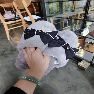 Grey fluffy cotton slippers detail, soft plush house shoes with elegant black bow ribbons.