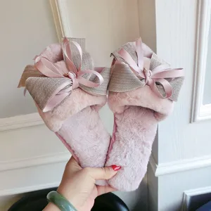 Close-up detail of cozy plush open-toe slippers featuring a chic large bow, soft pink style.