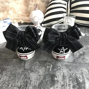 Black high-top canvas sneakers featuring large bowknot detail and custom graffiti accents.