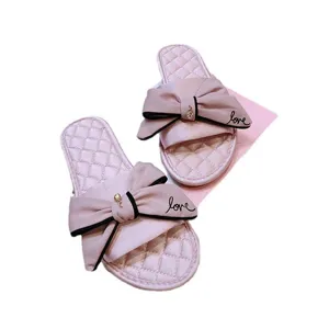 Pantoufles pour femmes en satin rose avec grand nœud et imprimé love doux pour la maison.