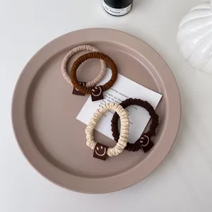 Vue détail de chouchous épais mignons avec de petites étiquettes sourire, élastiques cheveux.
