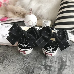 Black canvas sneakers featuring large back bow knots, creative graffiti embroidery and chic design.