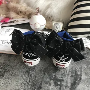 Black high-top canvas sneakers featuring exaggerated bowknot and stylish graffiti details.