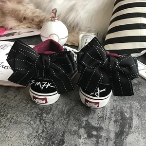 Black canvas sneakers with large back bow, stylish casual flat shoes for women daily wear.