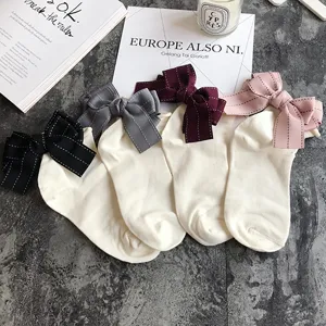 Detail closeup of cute women cotton socks featuring large bow knots in various colors.