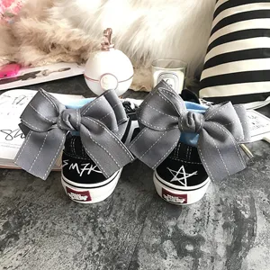 Cute bow canvas sneakers with blue socks and graffiti back design, trendy streetwear fashion detail.