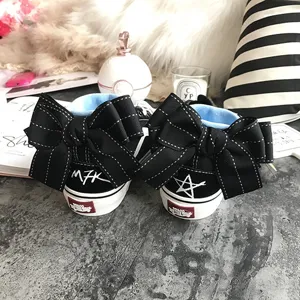 Black canvas high-top sneakers featuring large elegant black bows and unique heel details.