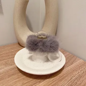 Détail de pince à cheveux en fourrure de vison grise, accessoire élégant pour l'hiver.