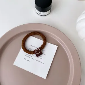 Élastique à cheveux marron avec jolie étiquette souriante pour coiffure de queue de cheval