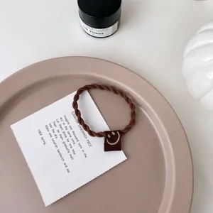 Chouchou tressé marron avec étiquette en tissu smiley mignon et élastique pour femmes.