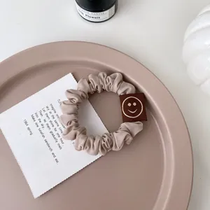 Chouchou de cheveux coréen mignon avec étiquette smiley brodée, attache élastique douce.