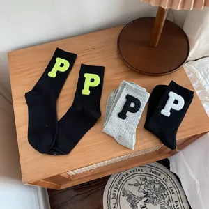 Detail view of Korean style mid tube warm socks featuring embroidered letter P patches.