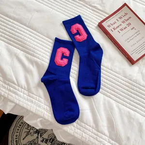 Blaue mittelhohe Baumwollsocken mit rosa Buchstaben C, gemütlich für Herbst und Winter.