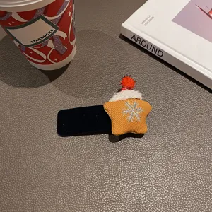 Detailansicht einer süßen Weihnachtsstern Haarnadel mit Plüschmütze und Schneeflocken.