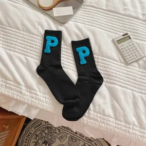 Detailed shot of black mid-tube socks featuring cute blue fluffy letter P patches.