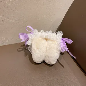 Gros plan detaille des cache-oreilles en peluche duveteuse avec dentelle et rubans.