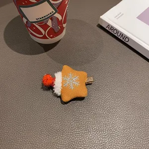 Detailansicht der weihnachtlichen Plüschstern-Haarspange mit Stickerei und kleiner Mütze.