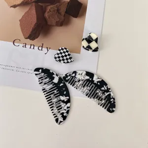 Detailed shot of black and white acetate hair combs and cute heart hair claws for daily styling.