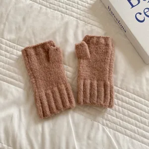 Primo piano di accoglienti guanti senza dita in maglia marrone con dettagli in lana.