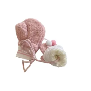 Cute winter warm baby plush mittens with pink fleece, hanging strings and fluffy pom-pom.