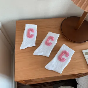 Chaussettes blanches tendance pour femmes avec patchs lettre rose pour un style quotidien.