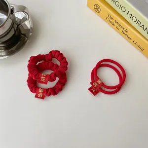 Red festive hair scrunchies and ties set with lucky embroidery tags for women hair styling.