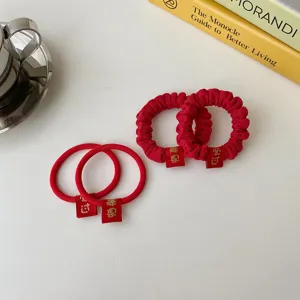 Red festive hair scrunchies and ties set with embroidered tags for new year styling.