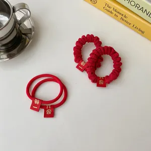 Red festive hair scrunchies with cute mini tags for festive new year styling detail view