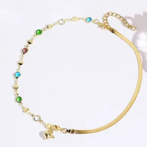 Gold-plated dolphin pendant necklace detail, featuring colorful stones and snake chain.