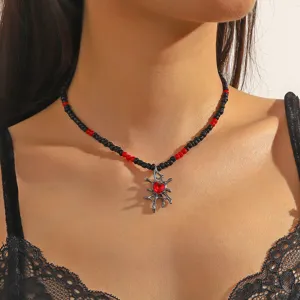 Close-up van de gotische zwarte en rode kraalketting met een unieke web-hangervariant.