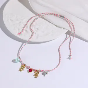 Close-up detail of the sweet braided necklace featuring cute boy and girl charms with heart.